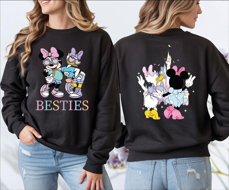 A woman wearing a black sweatshirt with a colorful design featuring Minnie Mouse and Donald Duck.