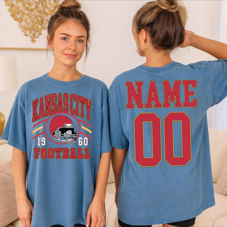 A woman wearing a blue Kansas City football t-shirt with the text "KANSAS CITY" and "1970 FOOTBALL" printed on it.