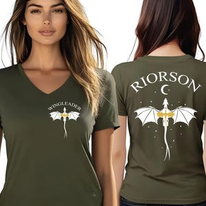 A woman wearing a green t-shirt with a white dragon design and the text "WINGLEADERRI" printed on it.