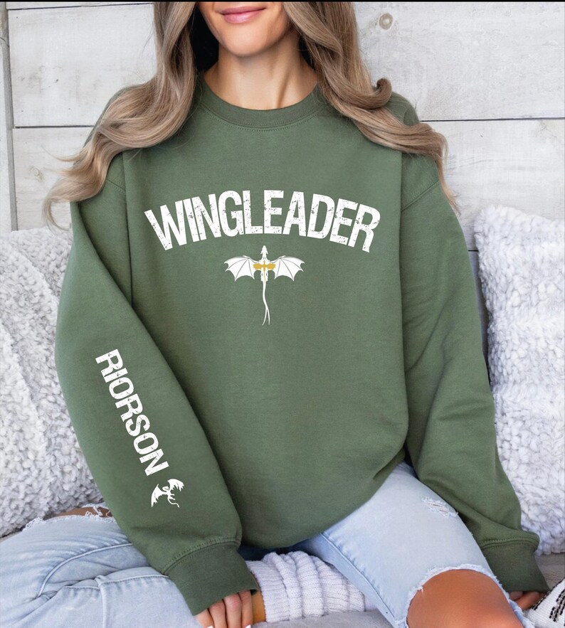 a woman sitting on a couch wearing a green sweatshirt
