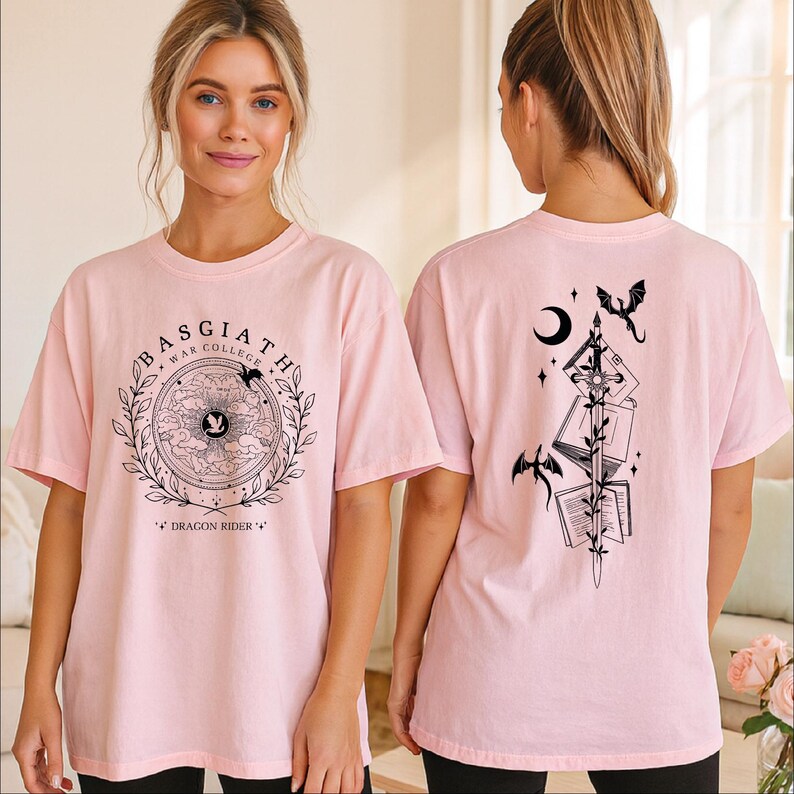 A woman wearing a pink t-shirt with a graphic design on the front and a back featuring a black illustration of a dragon and other symbols.