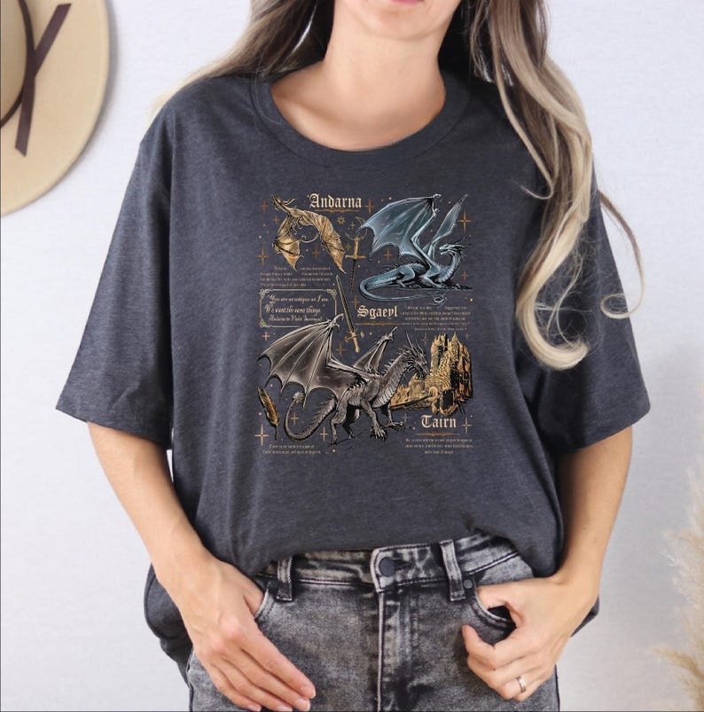 A woman wearing a gray t-shirt with a graphic design featuring a dragon and text related to the dragon.