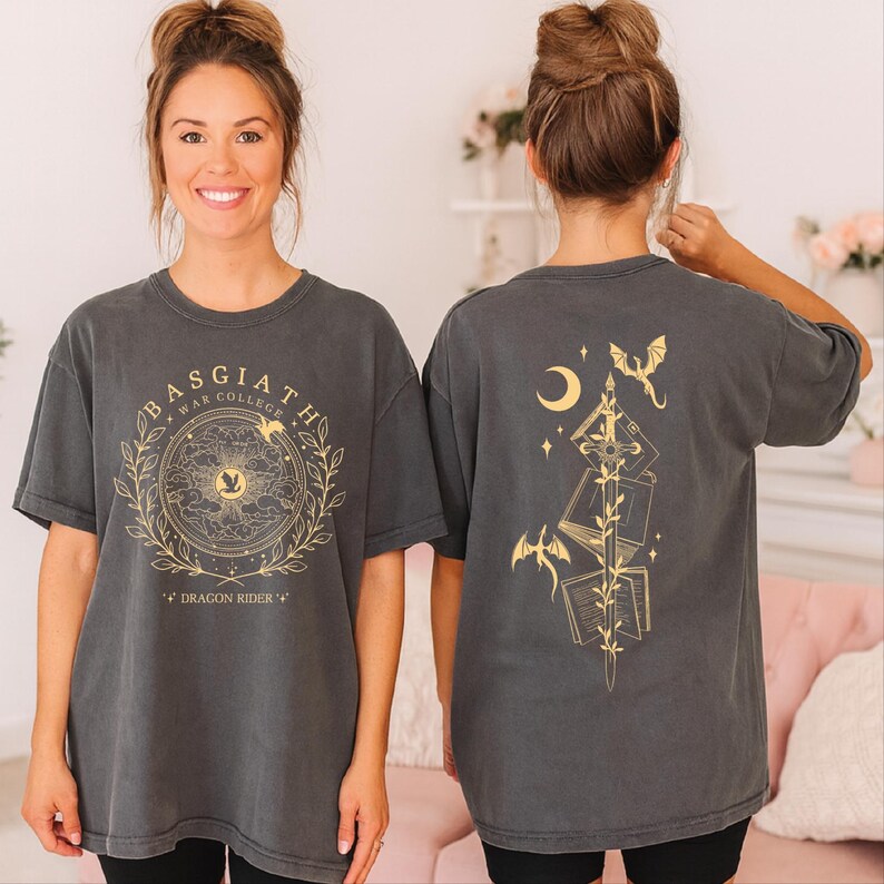 A woman wearing a grey t-shirt with a graphic design on the front and a back featuring a dragon and a crescent moon.