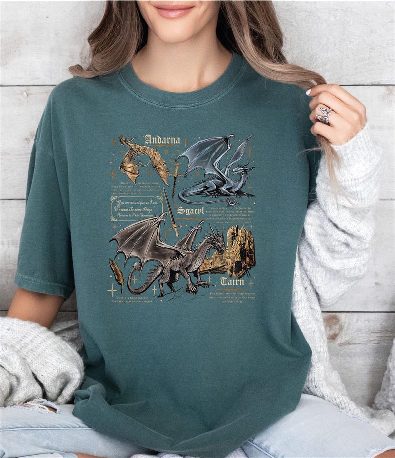 A woman wearing a green t-shirt with a graphic design of two dragons and text that appears to be a description or information about the dragons.
