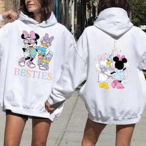A woman wearing a white hoodie with a cartoon character design on the front and back.