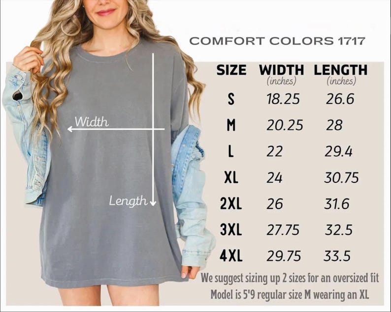 a woman wearing a gray t-shirt with measurements and sizes listed below it.