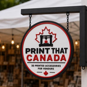 Peut inclure: Une enseigne suspendue circulaire avec un cadre noir et une face blanche, arborant une feuille d'érable rouge, une icône d'imprimante 3D noire et le texte PRINT THAT CANADA, 3D PRINTED ACCESSORIES FOR VENDORS, suspendue par deux chaînes noires.