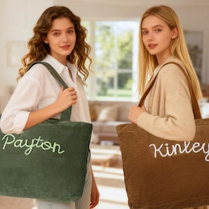 May include: Two corduroy tote bags, one green and one brown, each with a name embroidered in a contrasting color. The green bag says "Payton" in light green, and the brown bag says "Kinley" in white. Both bags have long handles.