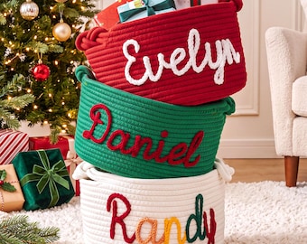 May include: Three stacked round rope storage baskets. The top red basket features the white stitched name Evelyn. The middle green basket has the red stitched name Daniel. The bottom white basket displays the multicolored stitched name Randy.