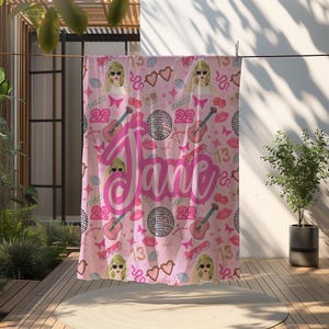 May include: Pink fleece blanket with a repeating pattern of a singer's face, hearts, guitars, butterflies, and the words "Fearless 22" and "13". The name "Jane" is written in large pink letters.