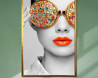 May include: A black and white portrait of a person wearing large, round sunglasses with colorful rhinestones. The sunglasses have a gold frame. The person is wearing bright orange lipstick.