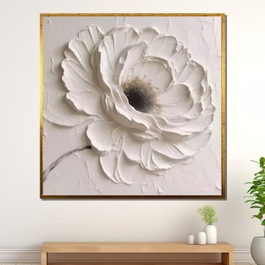 May include: A white flower with a textured, 3D effect, painted in a minimalist style. The flower is the focal point of the painting, with a white background and a subtle gold frame.