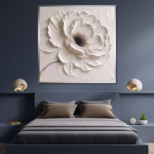 May include: A white flower with a textured, 3D effect, painted on a canvas. The flower is in focus, and the background is a soft, light pink.