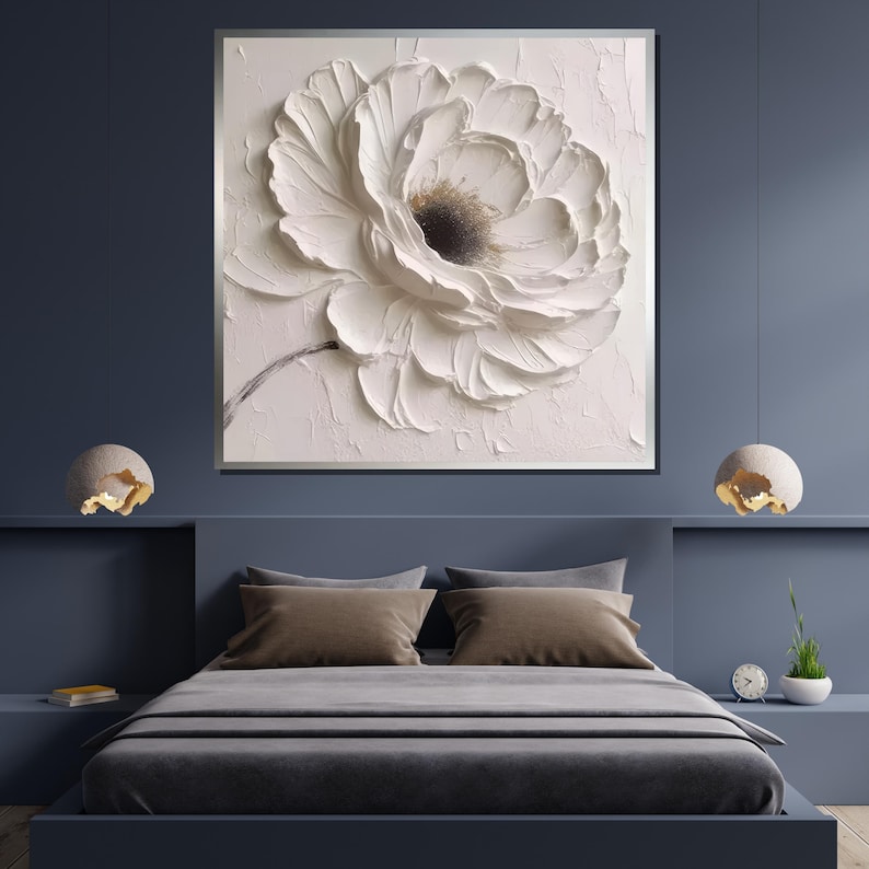 May include: A white flower with a textured, 3D effect, painted on a canvas. The flower is in focus, and the background is a soft, light pink.