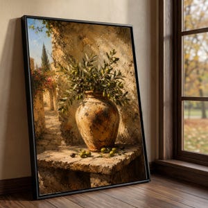 May include: A framed wall art print depicting a large, weathered terracotta vase filled with olive branches, resting on a stone ledge. The scene features a sunlit Mediterranean stone pathway with blooming flowers and a tall cypress tree in the distance.