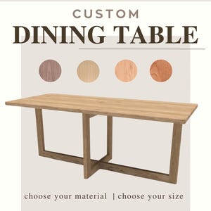 May include: A custom dining table with a light wood finish and a rectangular top. The table has a unique base design with angled legs and an X-shaped support. The image includes text that says "CUSTOM DINING TABLE", "choose your material | choose your size", and "THE BJÖRN".