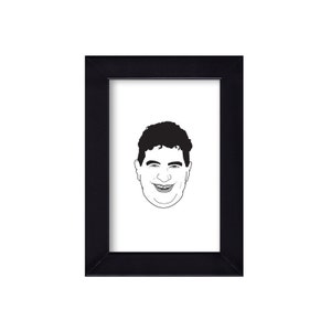 May include: A black framed portrait featuring a black and white line drawing of a smiling person's face. The person has dark, curly hair and a wide smile. The portrait is set against a white background.