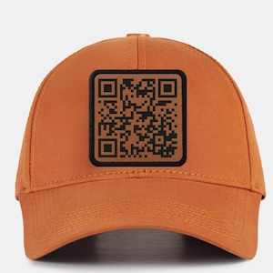 May include: A brown baseball cap with a black and white QR code patch on the front.