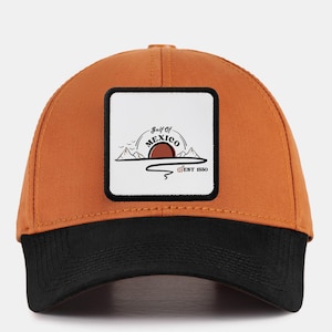 May include: A brown and black baseball cap with a patch that says "Gulf of Mexico est 1990" and a graphic of a sunset over mountains.