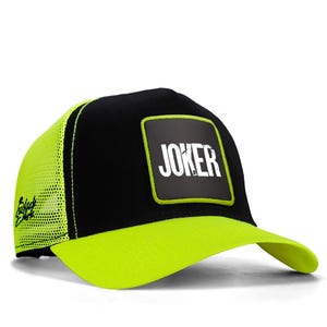 May include: Black and neon green trucker hat with the word "JOKER" in white block letters on a black square patch. The hat has a neon green brim and mesh back. The brand name "Black Shark" is on the side.