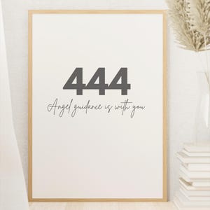 May include: A framed print with a white background and a black number 444 in large font. The text "Angel guidance is with you" is written in cursive below the number.
