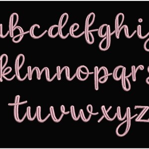 May include: A complete alphabet in a cursive, handwritten style. The letters are in a soft pink color and are displayed against a solid black background. The letters are in lowercase and are evenly spaced.