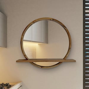 May include: A round wooden mirror with a shelf. The mirror has a natural wood grain finish and a circular shape. The shelf is rectangular and made of the same wood. The mirror is mounted on a light-colored wall.