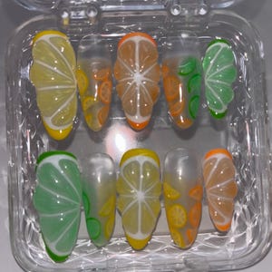 Citrus Squeeze press on nails | lemon, lime and orange fruit nails | shown on sculpture oval shape