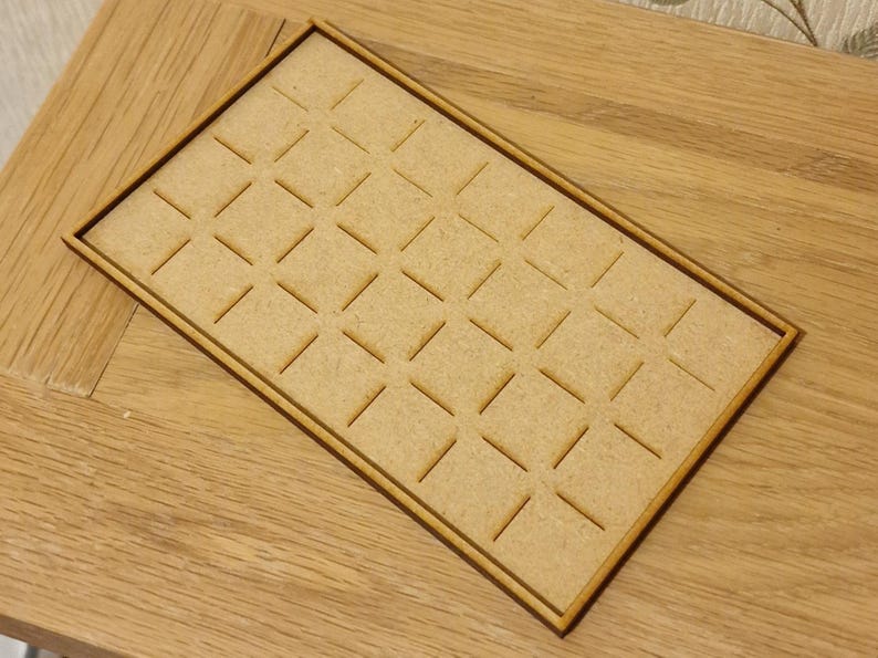 May include: A wooden tray with a grid pattern of square compartments. The tray is made of light brown wood and has a natural finish.