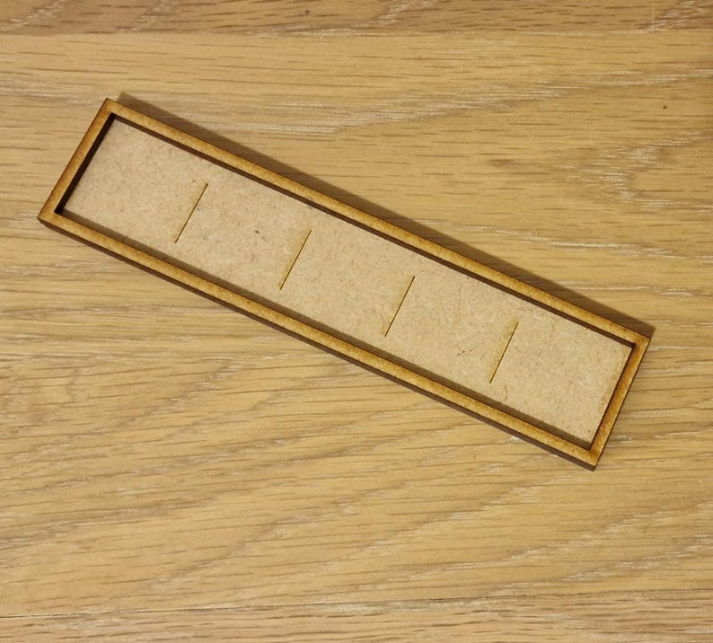 May include: A wooden tray with five slots for holding small items. The tray is made of light brown wood and has a natural finish.