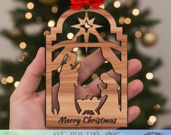 May include: Wooden Christmas ornament with a nativity scene cutout, a star, and the words "Merry Christmas." It has a red ribbon for hanging. The ornament is held in a hand.