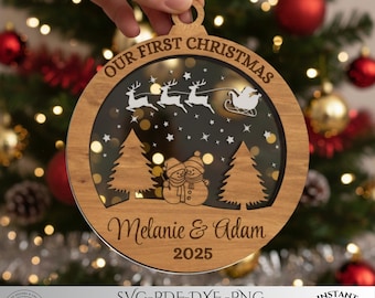 Puede incluir: Un adorno navideño redondo de madera con un diseño cortado a láser que incluye el texto "OUR FIRST CHRISTMAS" en la parte superior, "Melanie & Adam" en el centro y "2025" en la parte inferior. La escena muestra a Santa en un trineo, renos y muñecos de nieve.