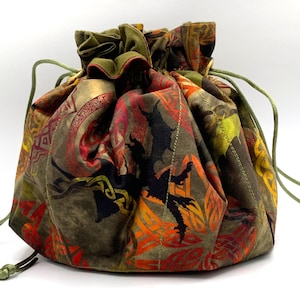 May include: A green drawstring bag with a red, orange, and yellow dragon pattern. The bag is made of fabric and has a drawstring closure.