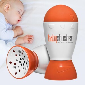 Op de afbeelding: Een witte en oranje baby-shusher geluidsmachine met een luidsprekerrooster en volumeknoppen. De tekst "babyshusher THE SLEEP MIRACLE" staat op het apparaat gedrukt.