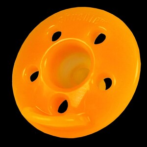 Op de afbeelding: Oranje plastic ring met vijf gaten en een centrale opening. De ring heeft de tekst "Sandpiper" erop gedrukt.