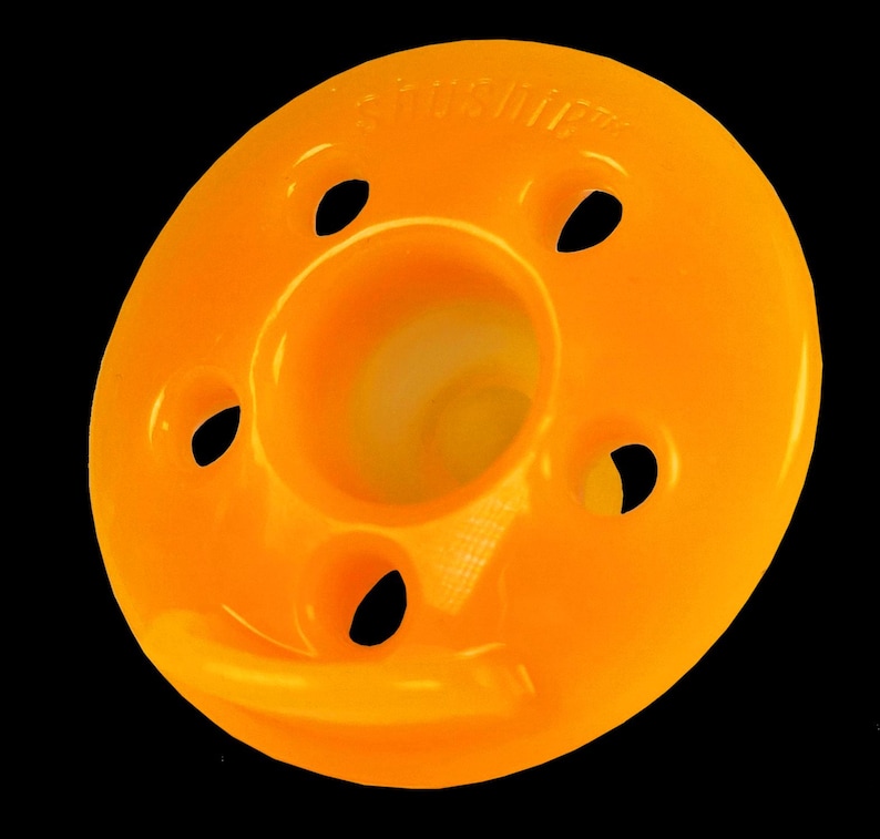 Op de afbeelding: Oranje plastic ring met vijf gaten en een centrale opening. De ring heeft de tekst "Sandpiper" erop gedrukt.
