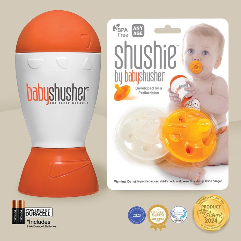 K&ouml;nnte beinhalten: Orangefarbene und wei&szlig;e Baby-Schlafger&auml;uschmaschine mit einem Schnuller und einem Baby auf der Verpackung. Die Verpackung tr&auml;gt den Schriftzug "shushie by babyshusher" und "Entwickelt von einem Kinderarzt".