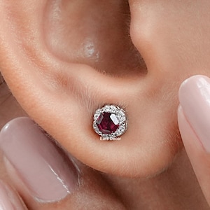 Peut inclure: Une paire de boucles d'oreilles en rubis et diamants. Les boucles d'oreilles présentent un rubis rond entouré d'un halo de diamants plus petits.
