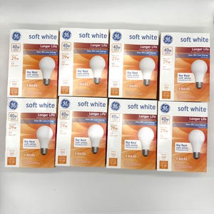 May include: A collection of GE soft white light bulb boxes. Each box displays a 40W bulb, with a 29W usage, and a longer life. The boxes are orange and white, with the GE logo and the words "soft white" prominently displayed.