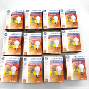 May include: Eleven GE soft white light bulb boxes arranged in a grid. Each box features a 2-pack label, a 40W equivalent rating, 29W power usage, and the text "Uses 28% Less Energy" and "LONGER LIFE" printed on the front of the packaging.