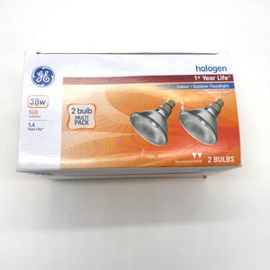 May include: A box of GE halogen light bulbs. The box is white with orange and brown accents and features the GE logo, bulb specifications, and the text "2 bulb multi pack". The box also states "Indoor Outdoor Floodlight".