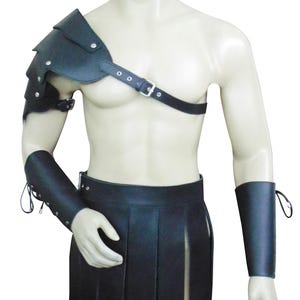 May include: Black leather gladiator armor set on a mannequin. The set includes a shoulder guard, chest strap, skirt, and arm cuffs. The armor is detailed with rivets and straps, and is designed for costume or cosplay.