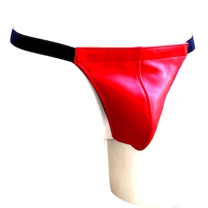 May include: A red thong-style undergarment with a black elastic waistband. The front of the garment is a solid, shiny red material. The elastic band is black and connects to the red fabric on each side.