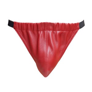 Puede incluir: Un slip de cuero rojo con forma triangular. Cuenta con una cintura fruncida con una banda elástica negra. El cuero es liso y brillante, con costuras visibles.