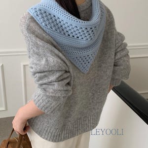 May include: A light blue triangular crochet hood with a textured openwork pattern worn over a grey long-sleeved knit jumper. The jumper features a ribbed hem and cuffs. The text LEYOOLI is visible in the lower right corner of the image.