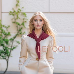 Op de afbeelding: Een vrouw met lang blond haar draagt een beige blazer met een donkerrode sjaal die om haar nek is geknoopt. De sjaal hangt aan de voorkant van de blazer. De vrouw kijkt naar de camera. De tekst "LEYOOLI" is zichtbaar in de afbeelding.