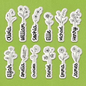 May include: A collection of white embroidered floral name patches on a green background. Each patch features a different flower design and a name in black script. Names include Olivia, William, Sophia, Ellie, Michael, Henry, Elijah, Amelia, Charlotte, Daniel, Emma, and James.