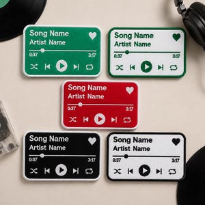 May include: Five rectangular embroidered patches featuring a music player interface design. Each patch displays the text Song Name and Artist Name, a progress bar with 0:37 and 3:17 timestamps, playback control icons, and a heart symbol.