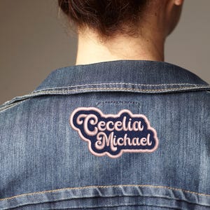 May include: A denim jacket with a pink and blue embroidered patch that says "Cecelia Michael"