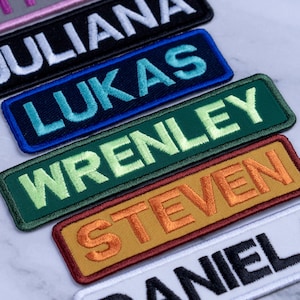 May include: Embroidered name patches in various colors. The names include JULIANA, LUKAS, WRENLEY, STEVEN, and DANIEL. Each patch has a contrasting border and embroidered text.